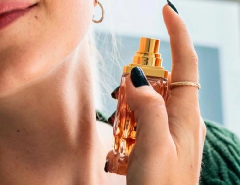 the woman is applying perfume