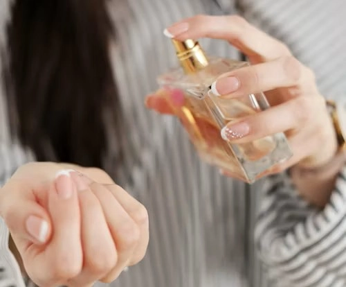 the woman is applying perfume